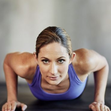 Shot of an attractive young woman doing pushups as part of her workout